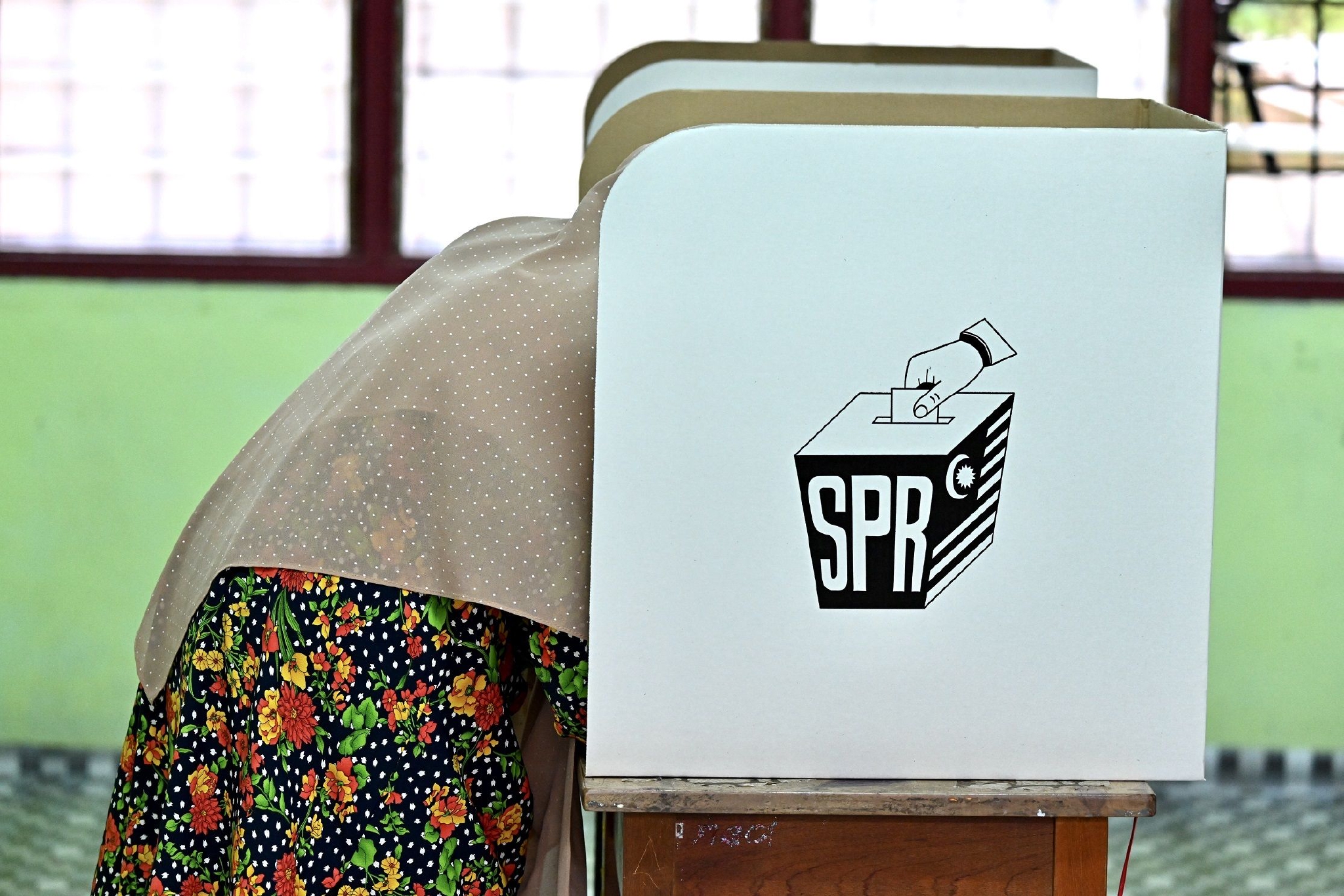 11月19日，选民在马来西亚彭亨州贝拉的一处投票站填写选票。图片来源：新华社